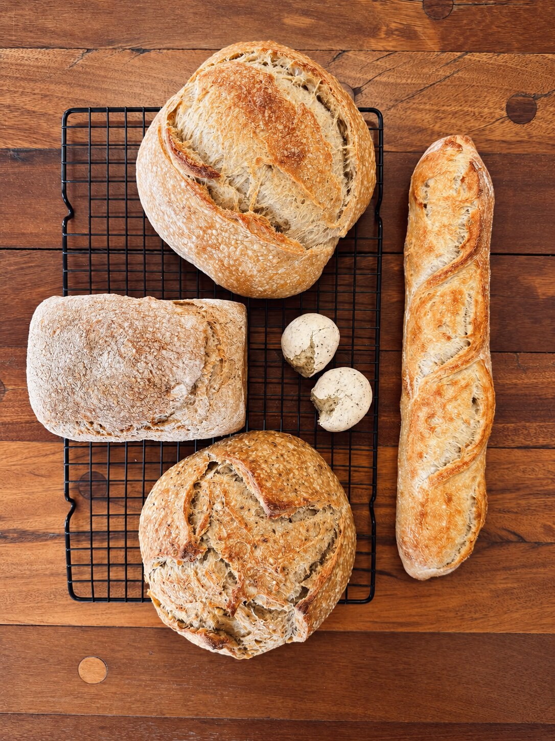 Amata’s artisan loaves on a cooling rack and wooden table